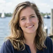 Portret van een glimlachende vrouw met halflang haar bij een zwembad